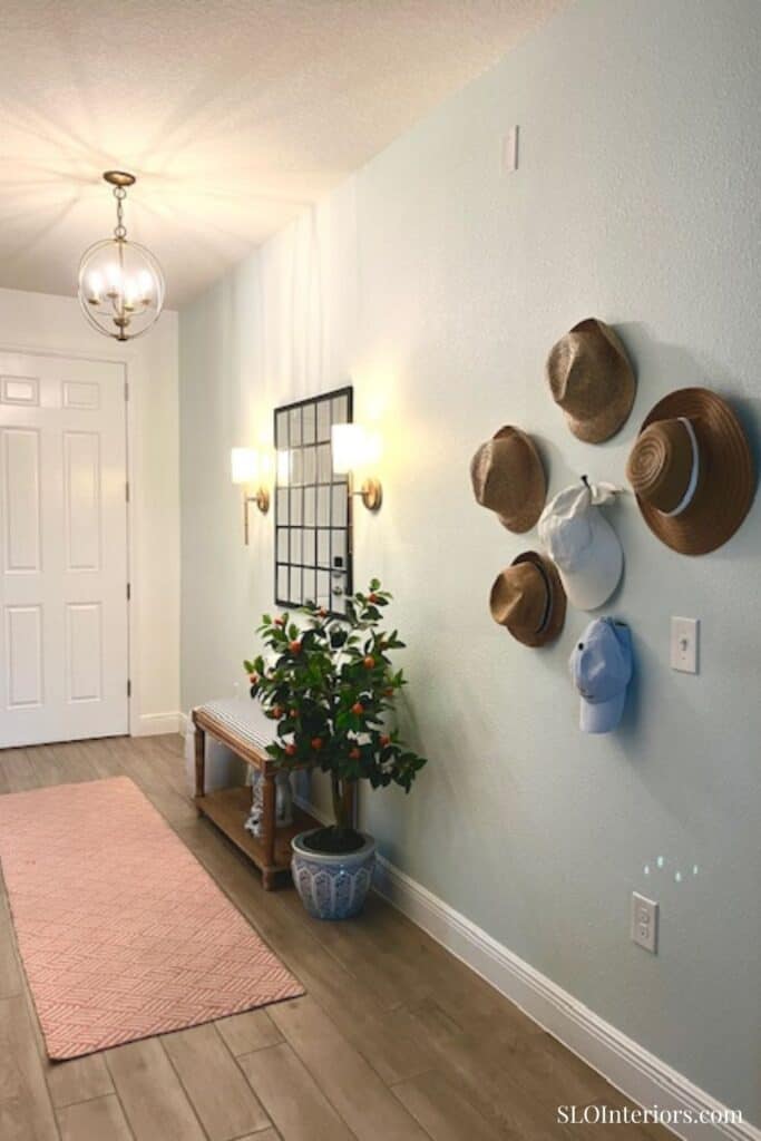 Entryway bench and rug with hats hanging on wall