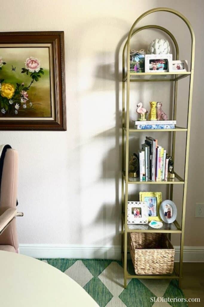 Gold bookshelf with photos, books and frames