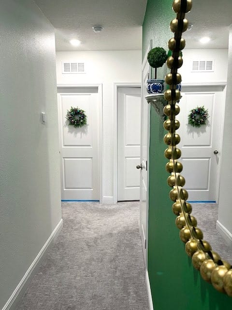 Green accent wall with wreath on door
