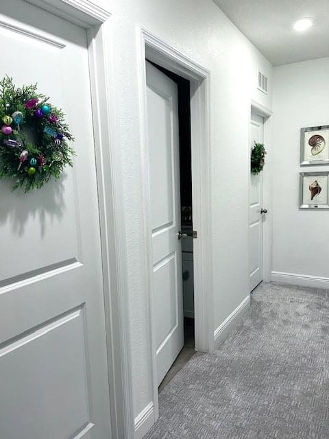 What hallway with doors and wreaths