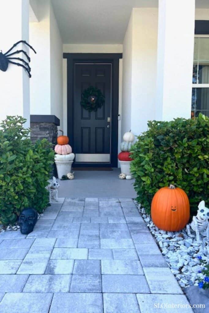 Orange pumpkins and skeleton decor front porch