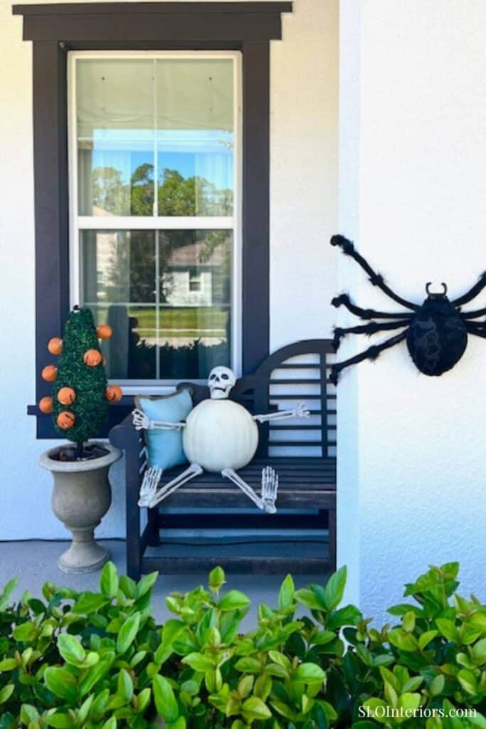 Fake black spider climbing front of white house