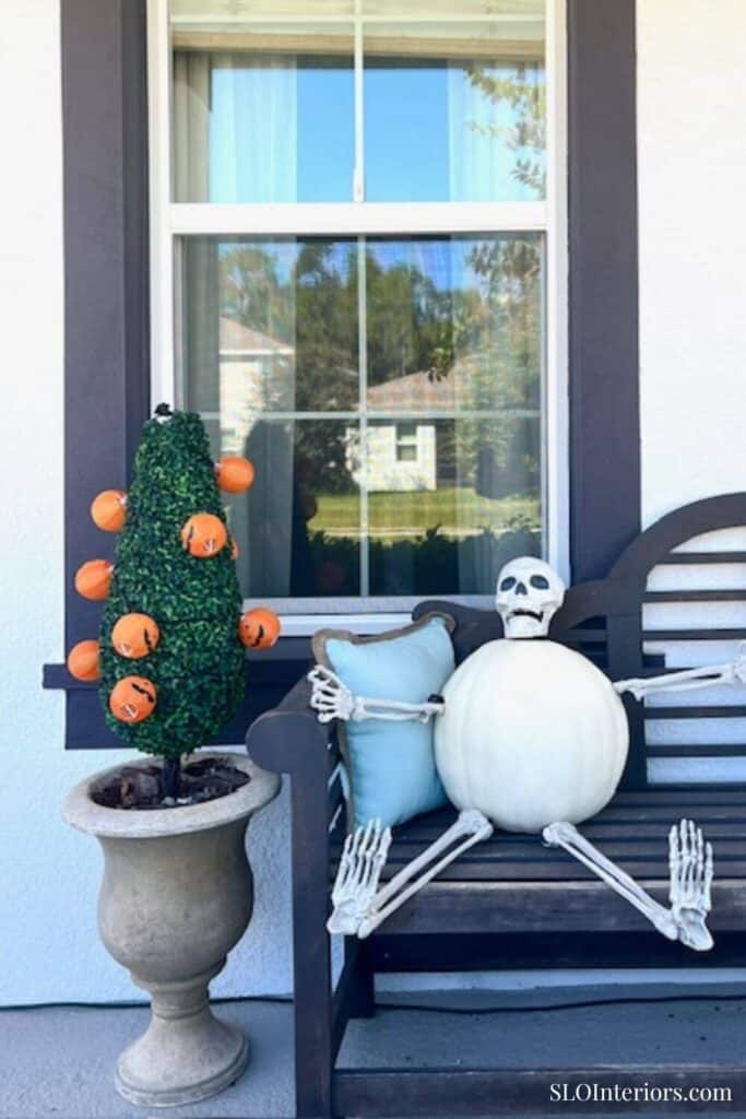 White pumpkin on black bench made into a skeleton