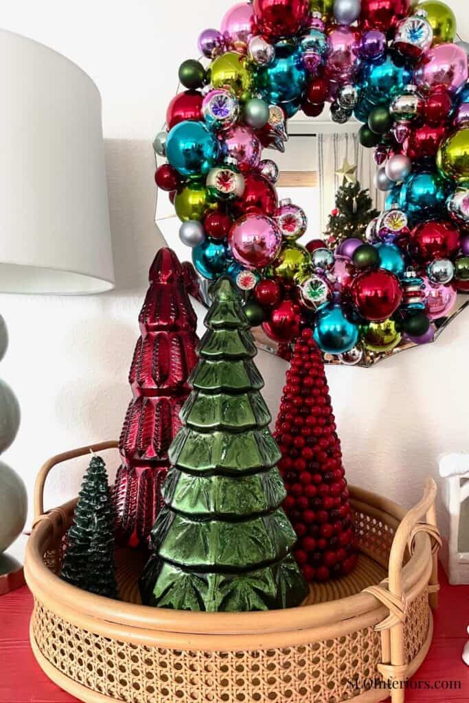 Bright Christmas wreath with colorful ornaments and decorative trees in a cozy home setting.