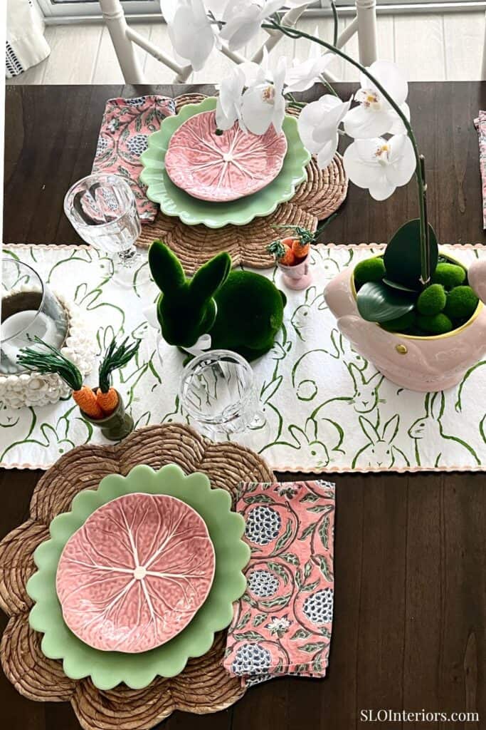A colorful Easter table setting with floral and bunny-themed decorations.