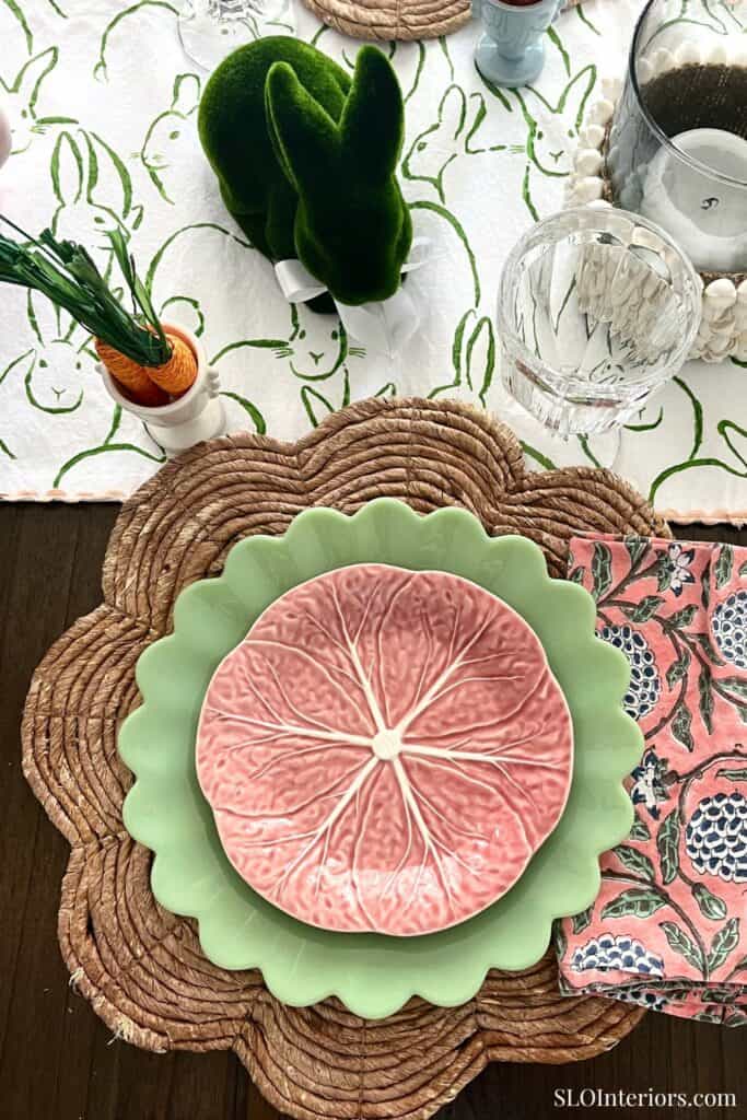 A lush green bunny-shaped plush toy on a table setting with decorative plates and tableware.