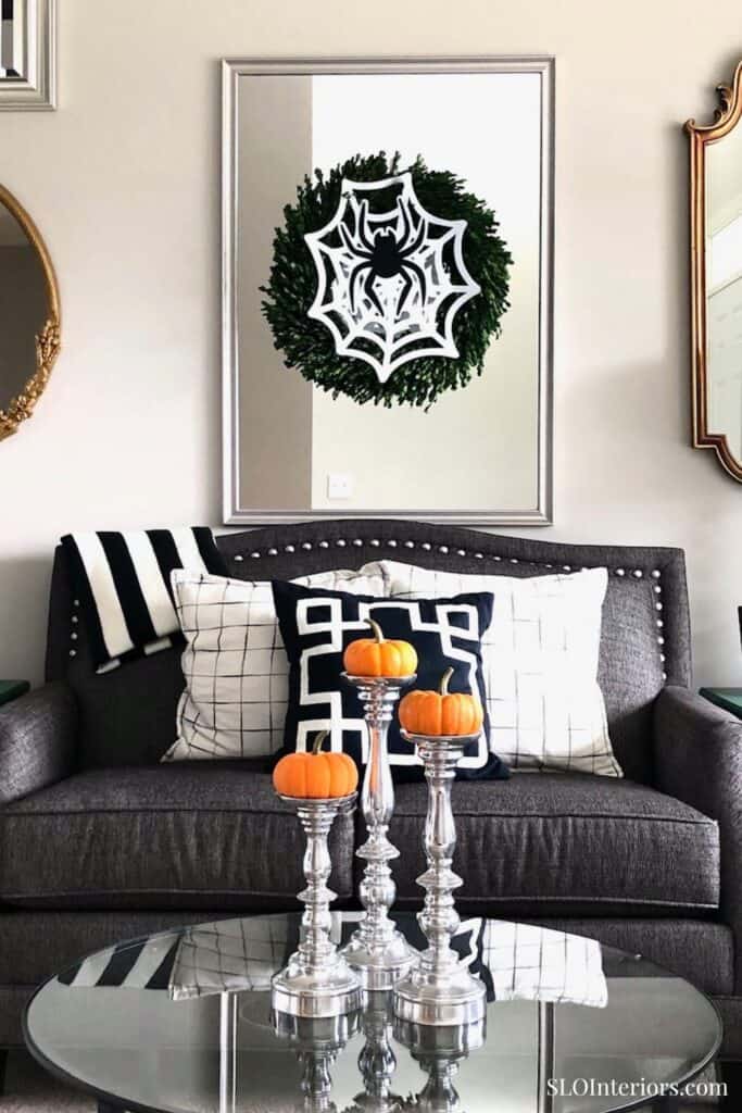 A cozy living room with Halloween decor, pumpkins, and modern furniture.