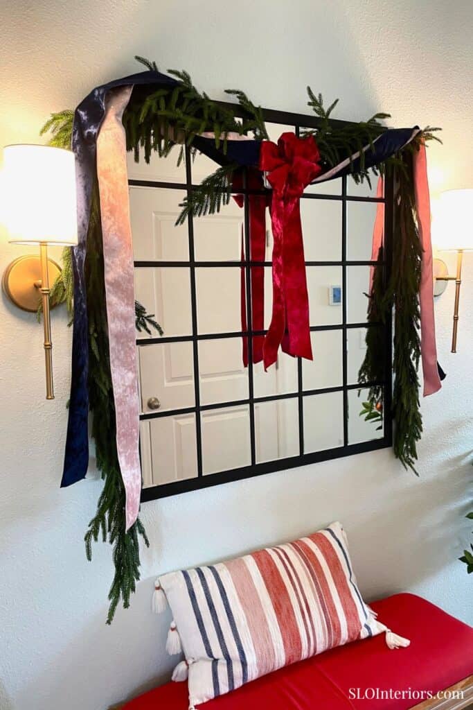 Festive holiday wall decor with ribbons and greenery in a cozy living room setting.