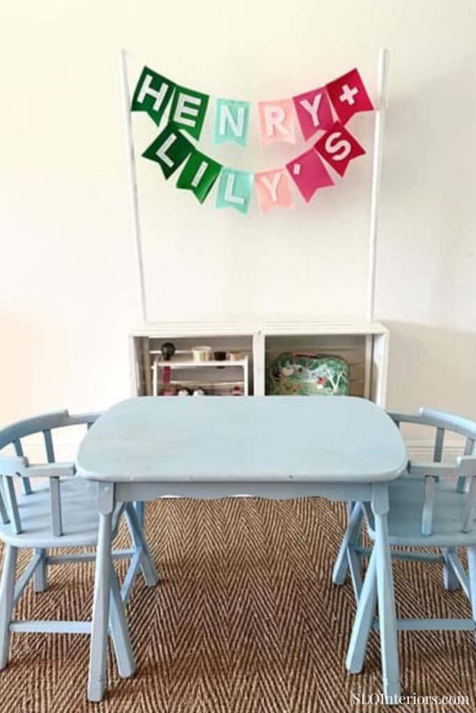 SLO Interiors, children's birthday party table with "HAPPY HOLLY DAYS" banner, kids' room decor.