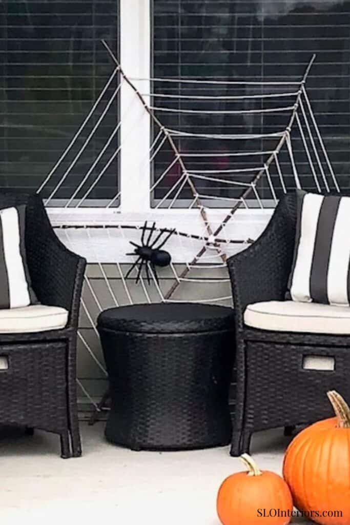Outdoor patio with black wicker chairs, striped cushions, and Halloween decorations.