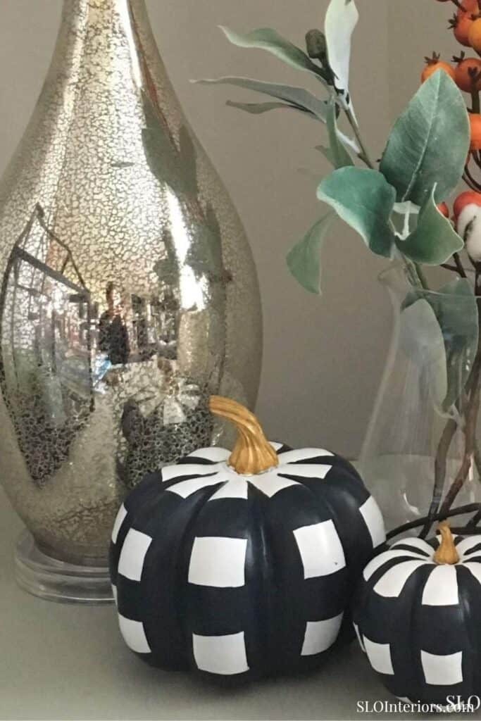 A decorative black and white checkered pumpkin with gold stem, modern interior decor.