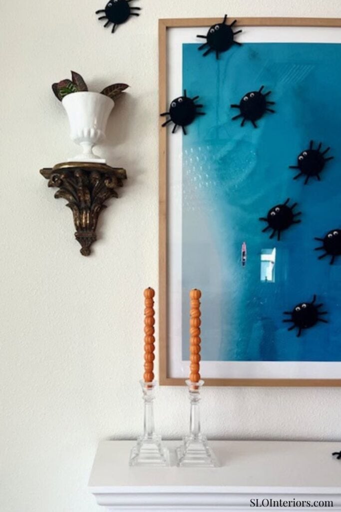 SLO Interiors modern wall art with black bug decor and blue background.