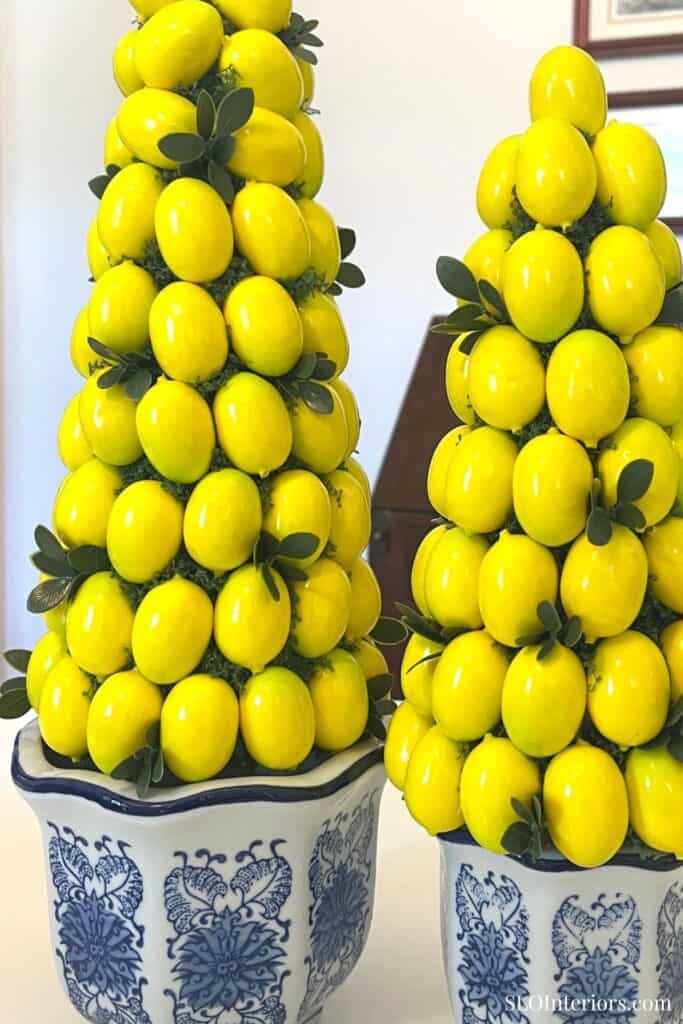 Bright yellow lemon topiary arrangements in decorative blue and white ceramic pots.