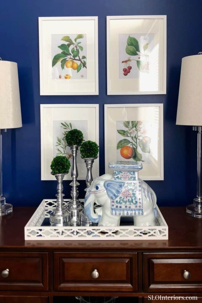 A colorful botanical wall art display with framed fruit illustrations in a modern interior setting.