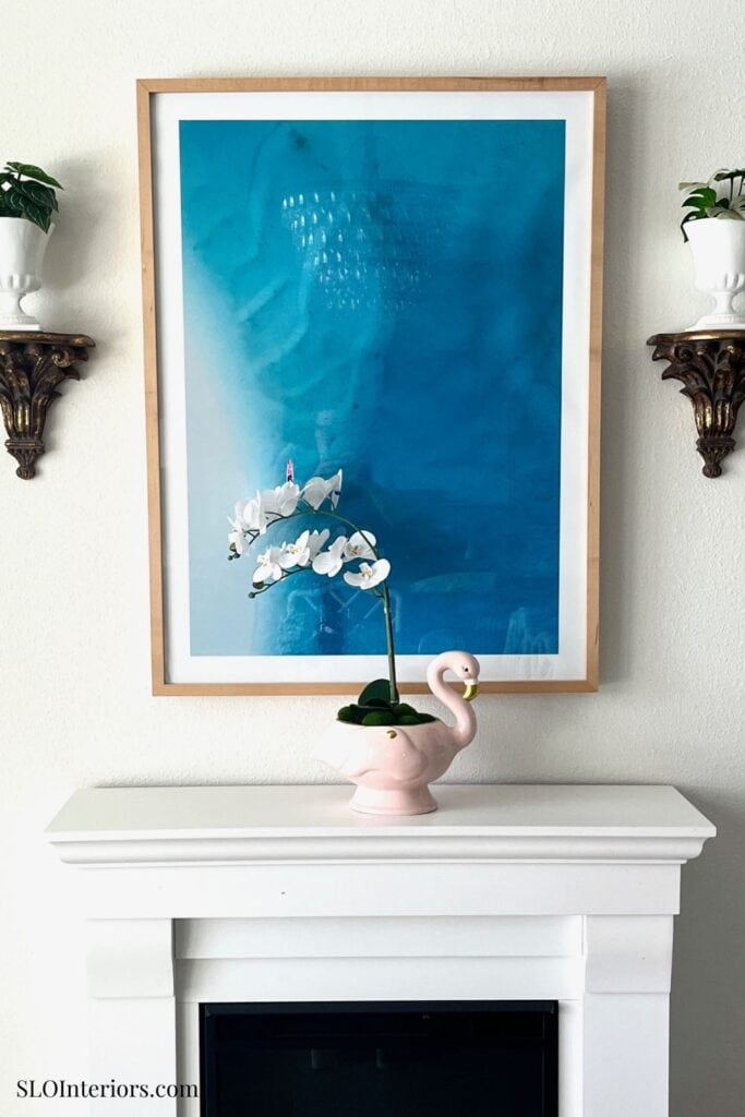 A colorful abstract wall art with white orchid and pink flamingo decor in a modern interior setting.