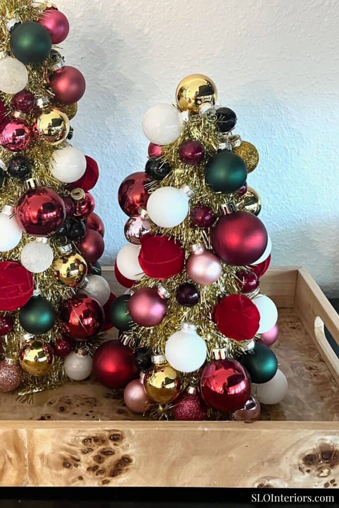 Festive Christmas trees decorated with colorful ornaments in a modern interior setting.