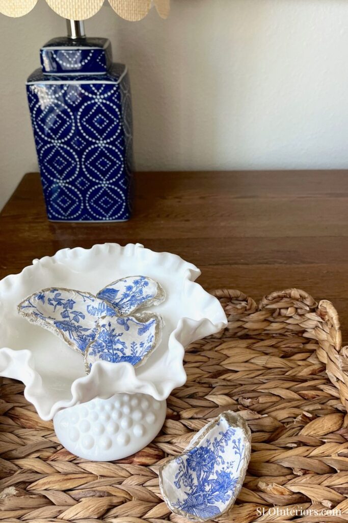 Blue and white decorative porcelain butterfly and shell ornaments on a white ceramic dish, with a bl.