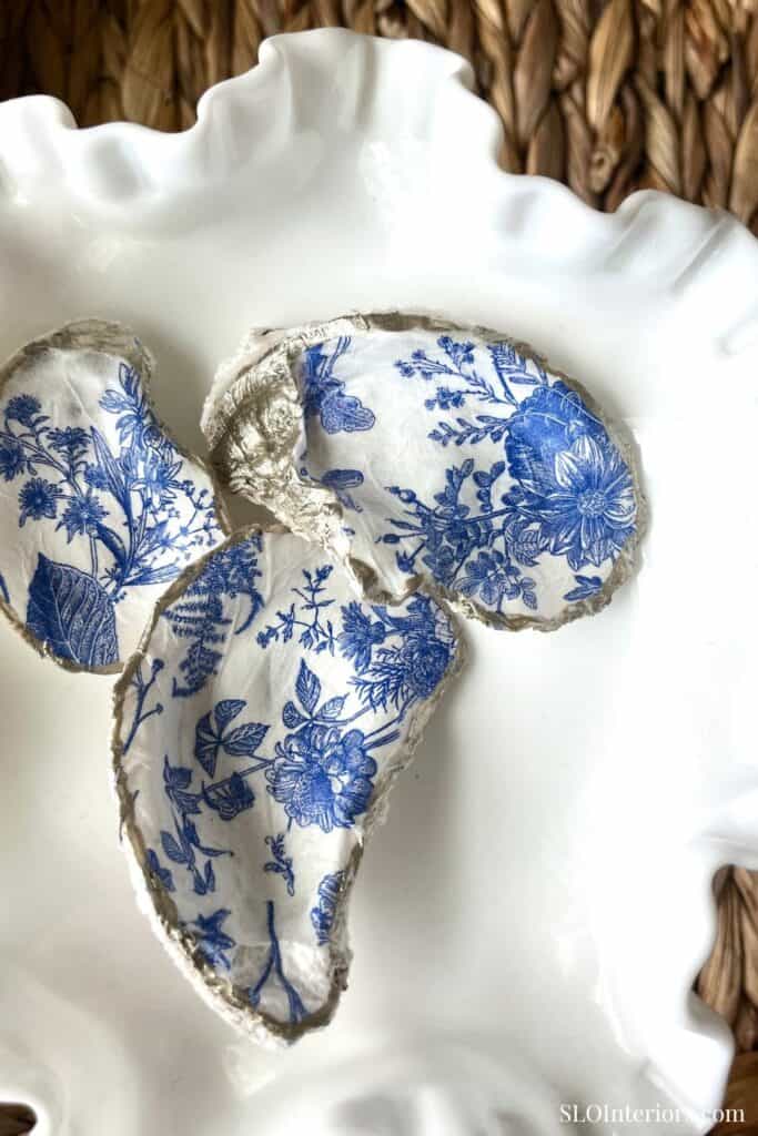 Vintage floral patterned ceramic plate with torn fabric, rustic background, SLO Interiors.