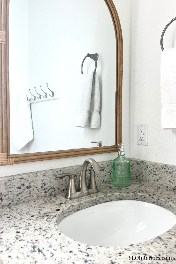 Bathroom faucet with granite countertop and bamboo framed mirror