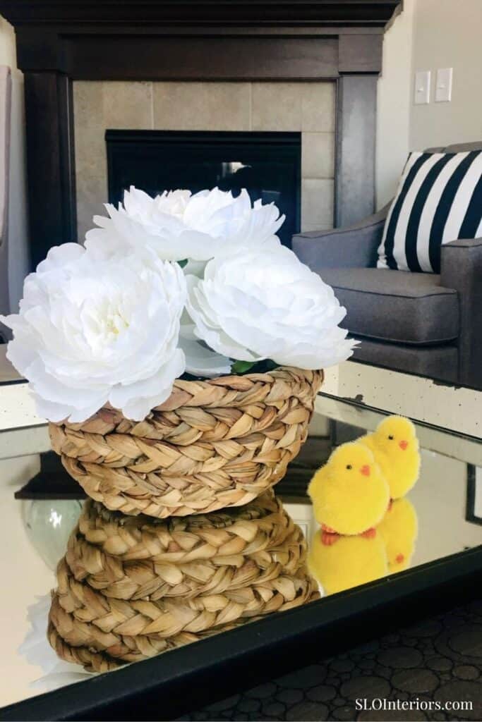 White artificial peony flowers in a woven basket, modern living room decor, SLO Interiors.