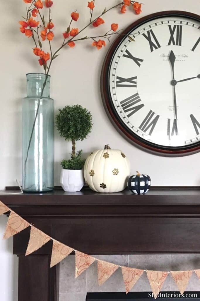 Elegant living room decor with clock, vases, and plants for stylish interior design.