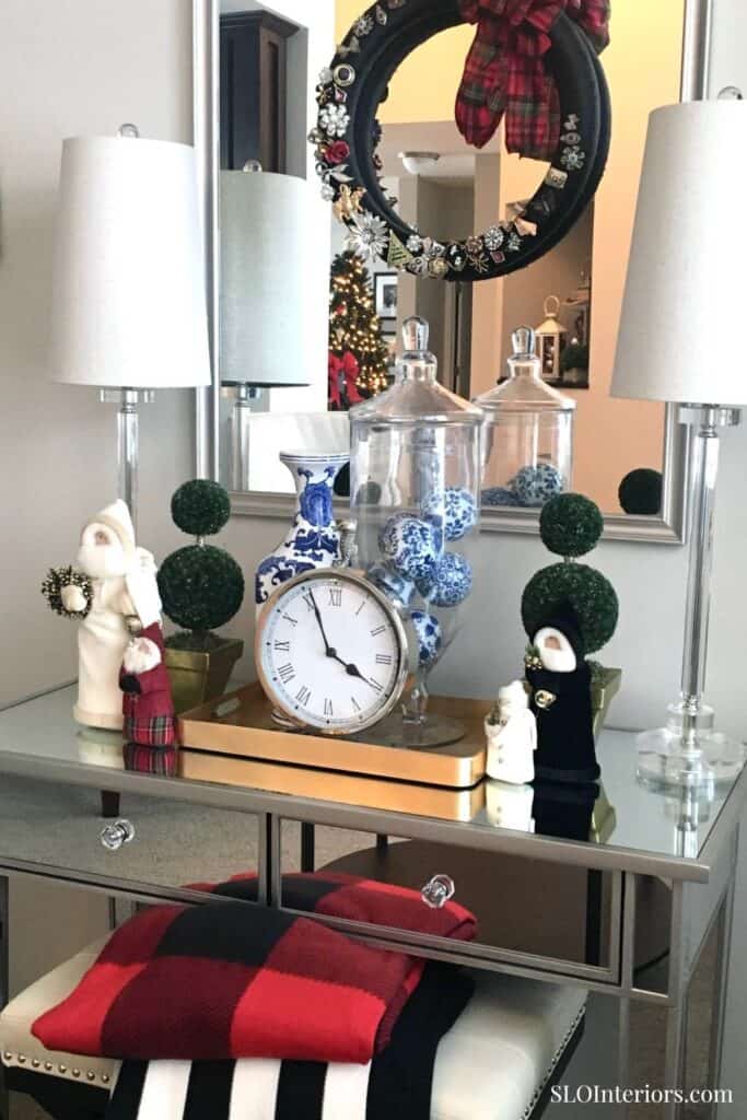 Festive holiday decor with clock, ornaments, and wreath in stylish interior setting.