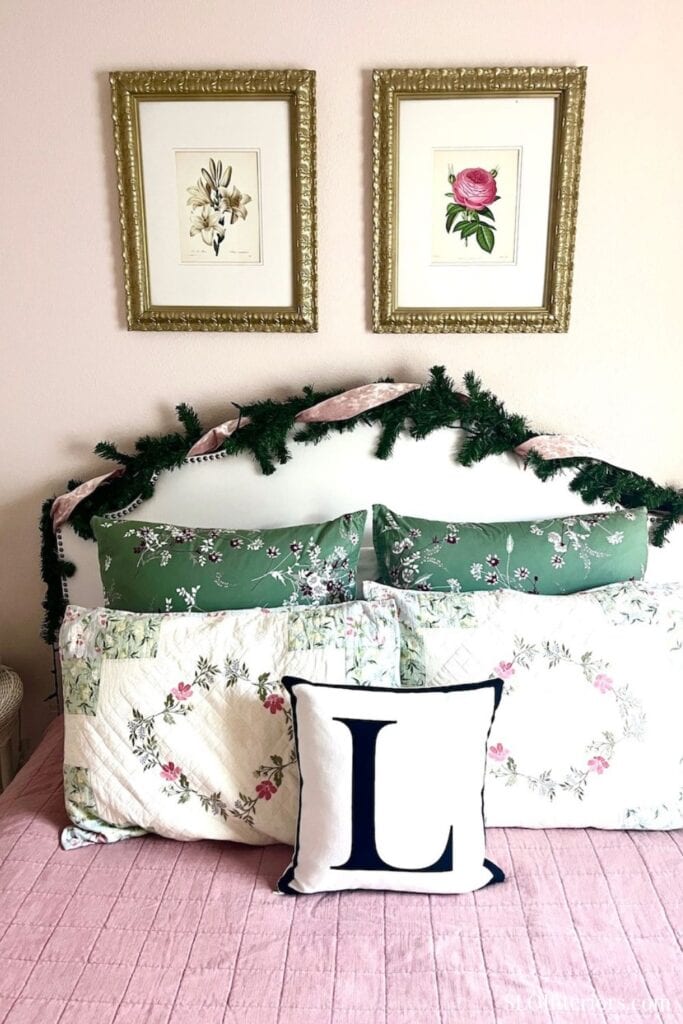 A cozy bedroom with floral artwork, decorative pillows, and festive greenery.