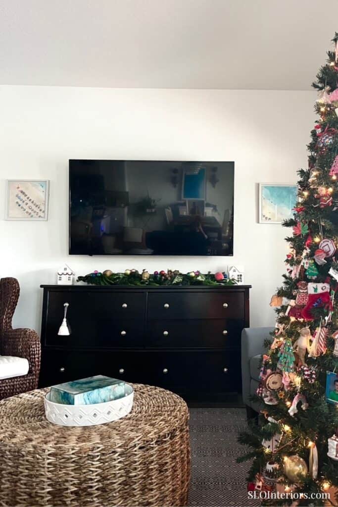 Elegant living room with Christmas tree, TV, and modern decor for holiday season.