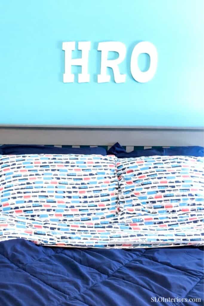 HRO sign on a light blue wall above a colorful patterned bedspread in a modern interior design.