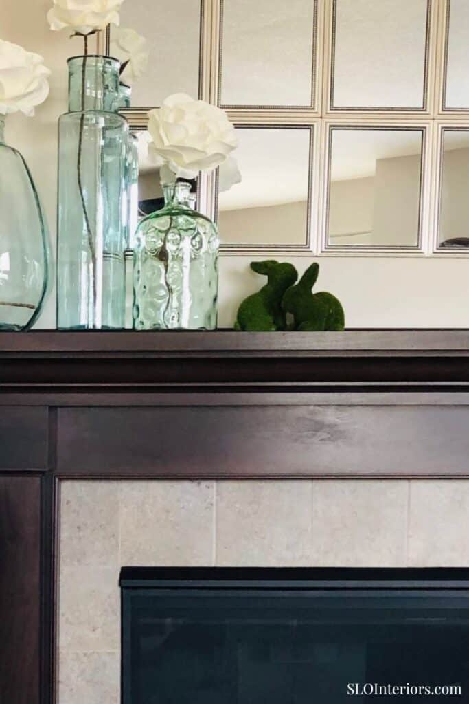 Elegant living room decor with vases, flowers, and a green bunny sculpture.