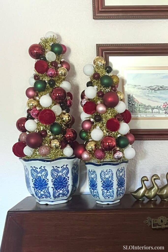 Festive Christmas trees with ornaments in blue and white planters, holiday decor, SLO Interiors.