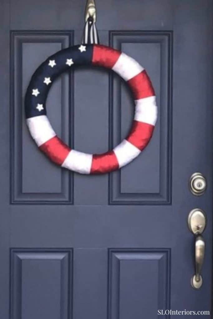 Patriotic door wreath with American flag colors and stars, decorative home entryway.