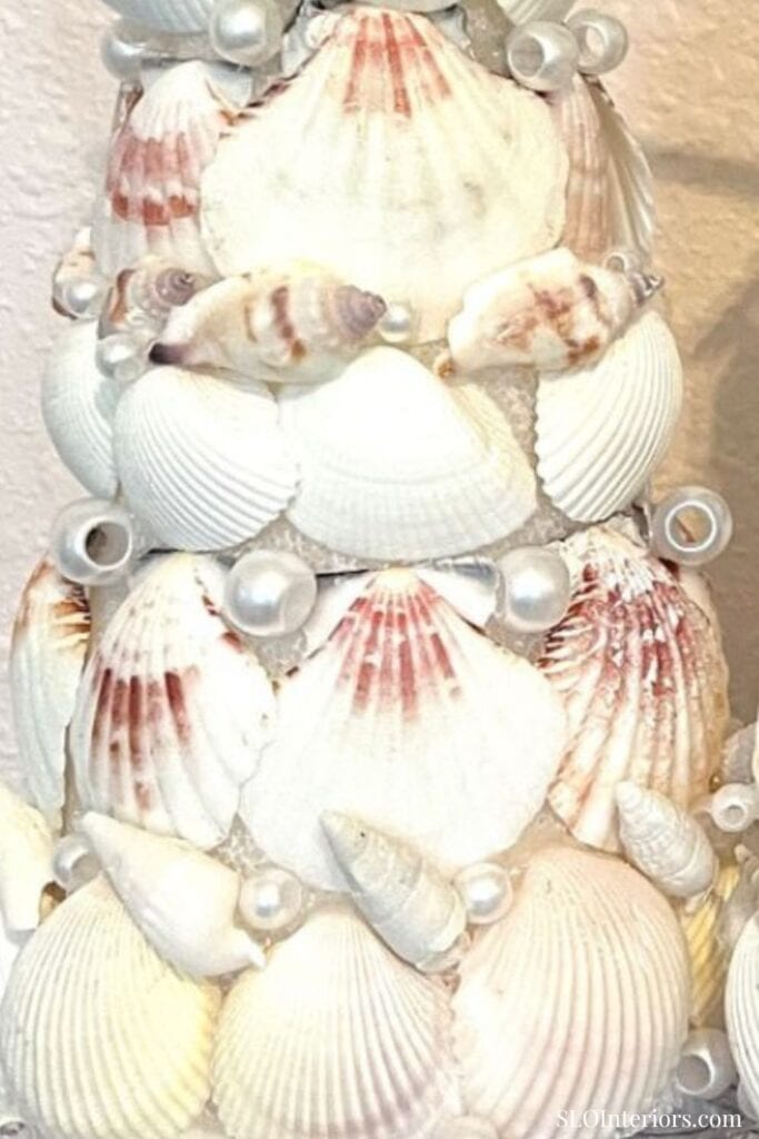A beach-themed decorative arrangement with seashells and pearls for coastal interior decor.