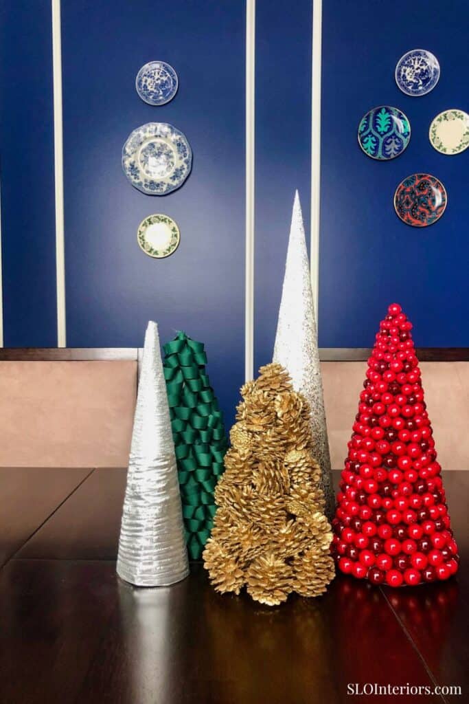 A festive holiday decor display with colorful cone-shaped Christmas trees and ornaments.