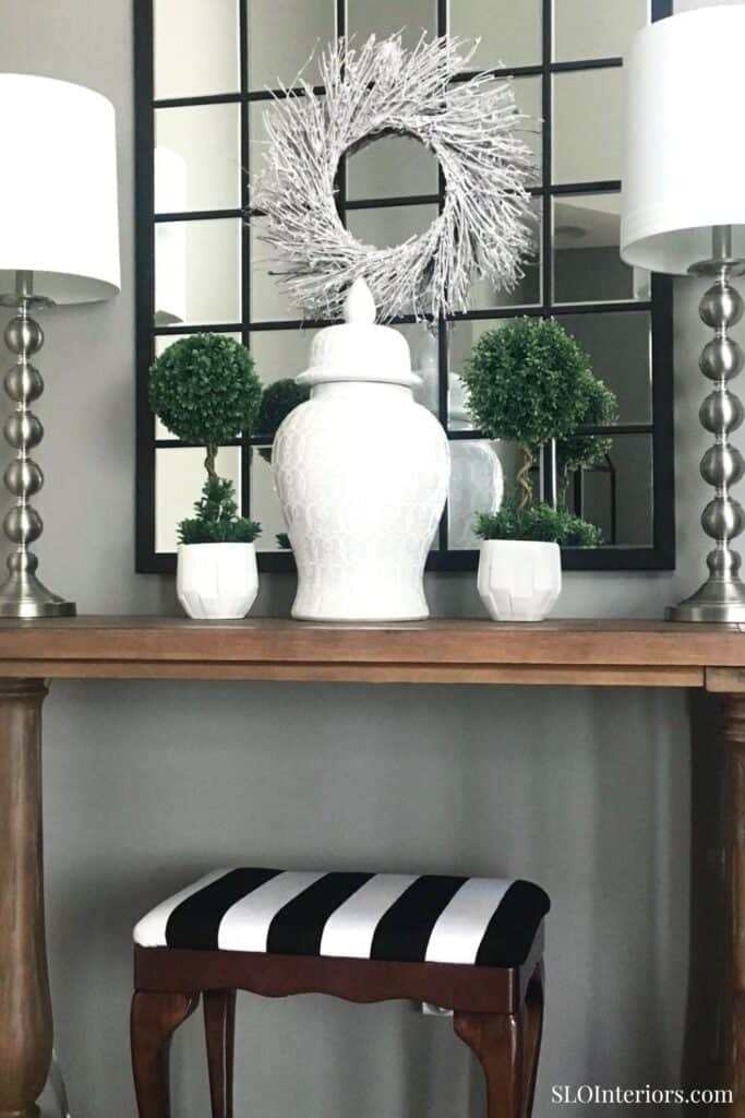 Elegant modern interior decor with white vases, green plants, and black-and-white accents.