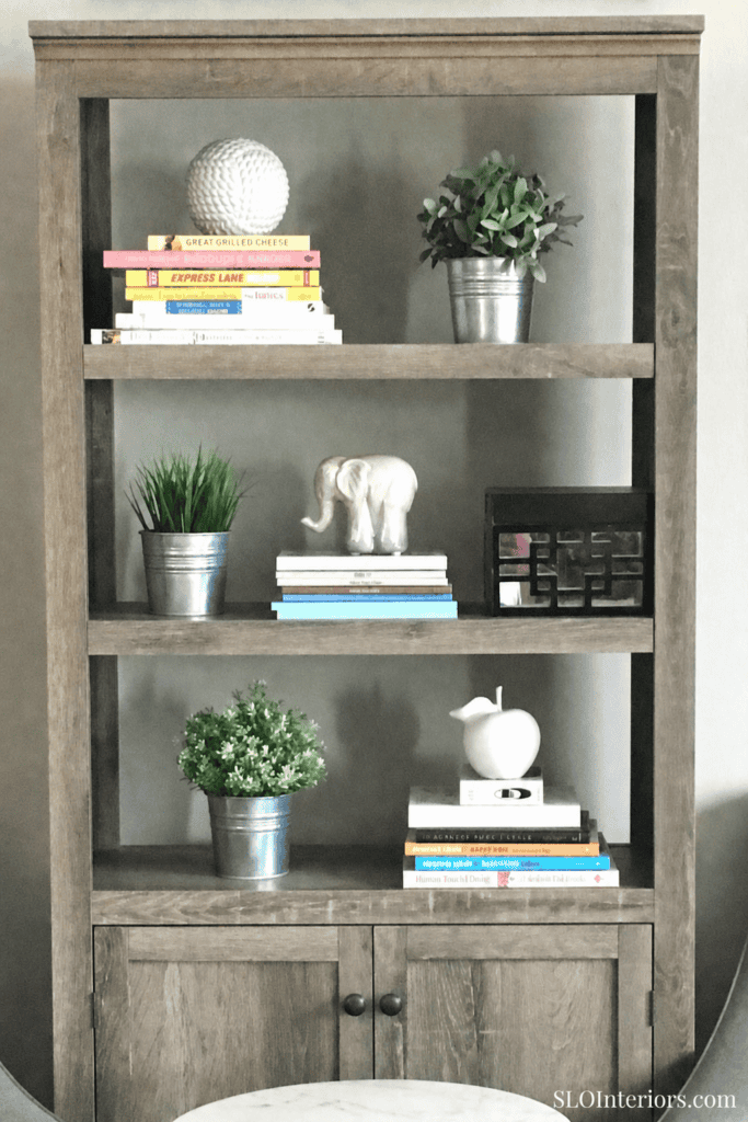 Modern wooden bookshelf with decorative plants, books, and elephant figurine for stylish interior de.