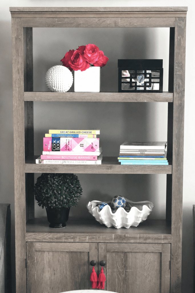 A cozy wooden bookshelf with decorative items and books in a modern interior setting.