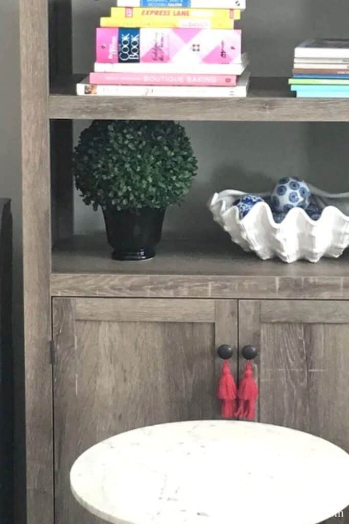 A lush green potted plant and decorative blue and white ceramic bowls on a wooden shelf in a modern.