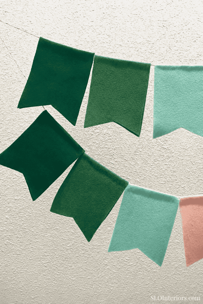 Green fabric bunting flags for interior decor, wall decoration, or party setting.