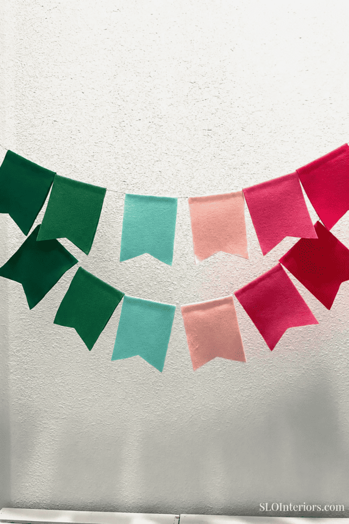 Festive paper banners in green, pink, and red for holiday decor and celebrations.
