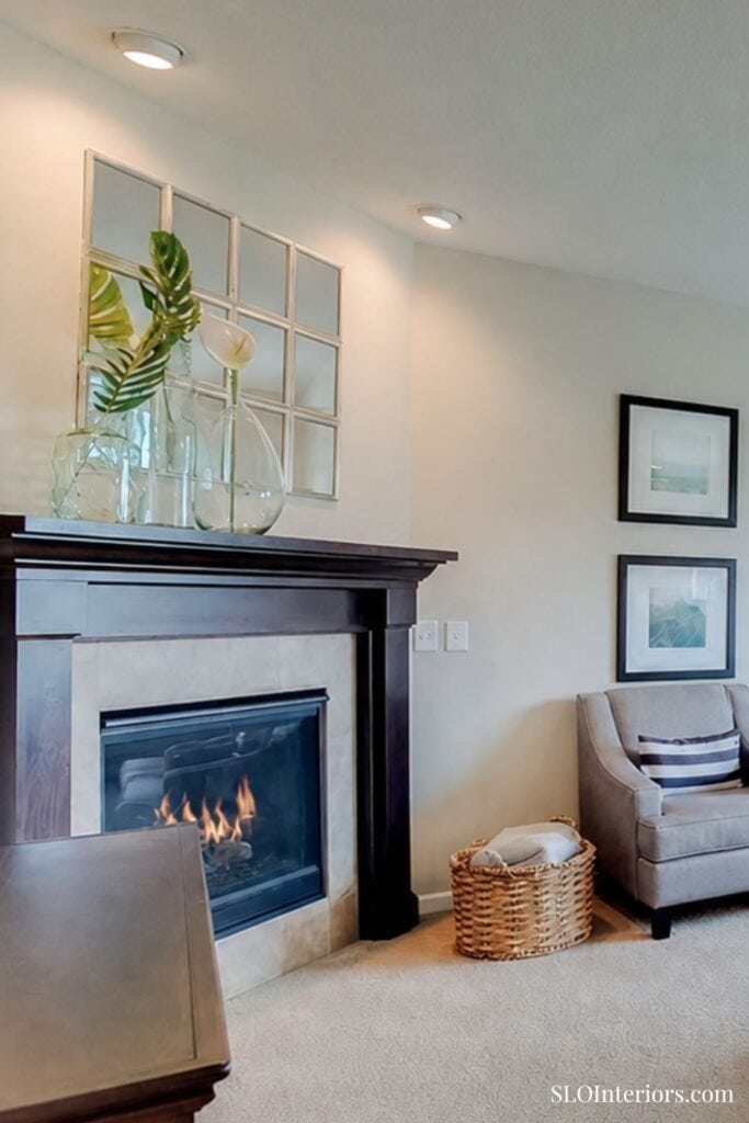 Modern living room with fireplace, sofa, and decorative wall art at SLO Interiors.