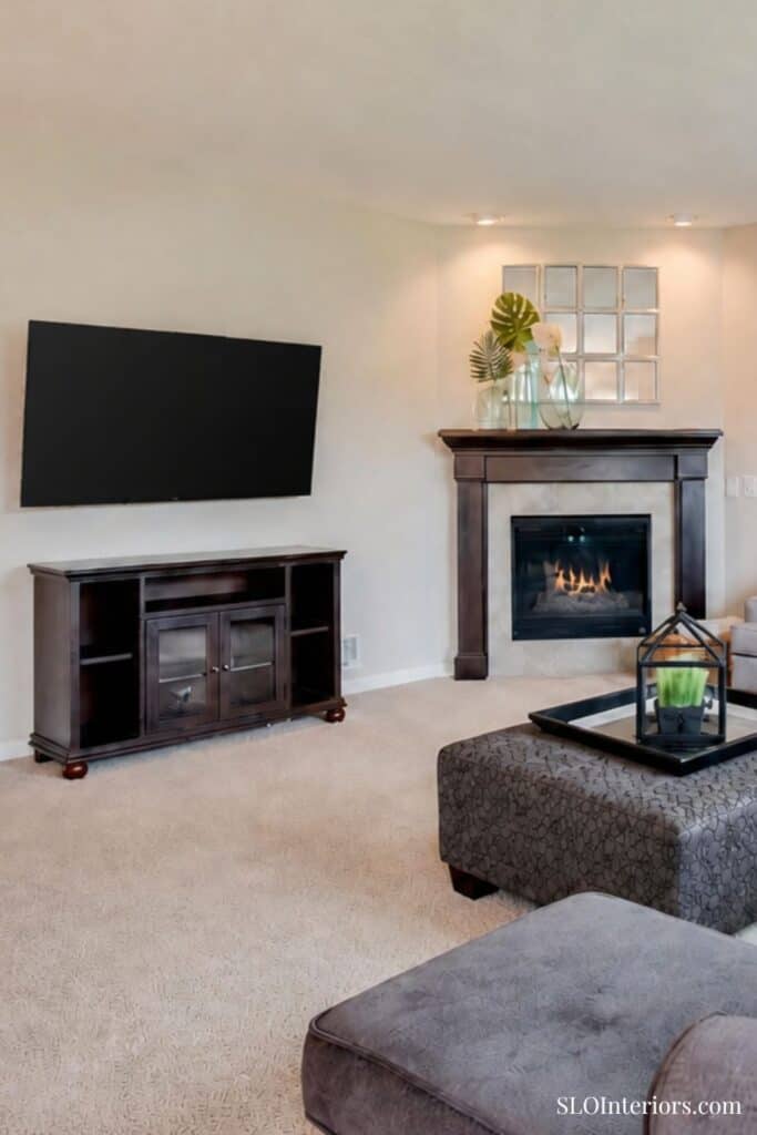 Modern living room with fireplace, TV, and stylish decor in SLO Interiors home.