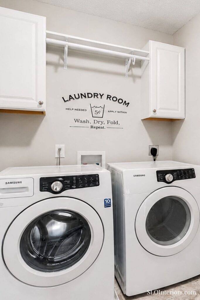 Wash, dry, fold laundry room with Samsung washer and dryer, white cabinets, and wall sign.