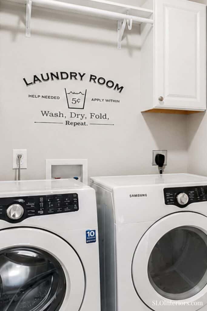 Clean laundry room with washing machines and wall sign for laundry instructions.