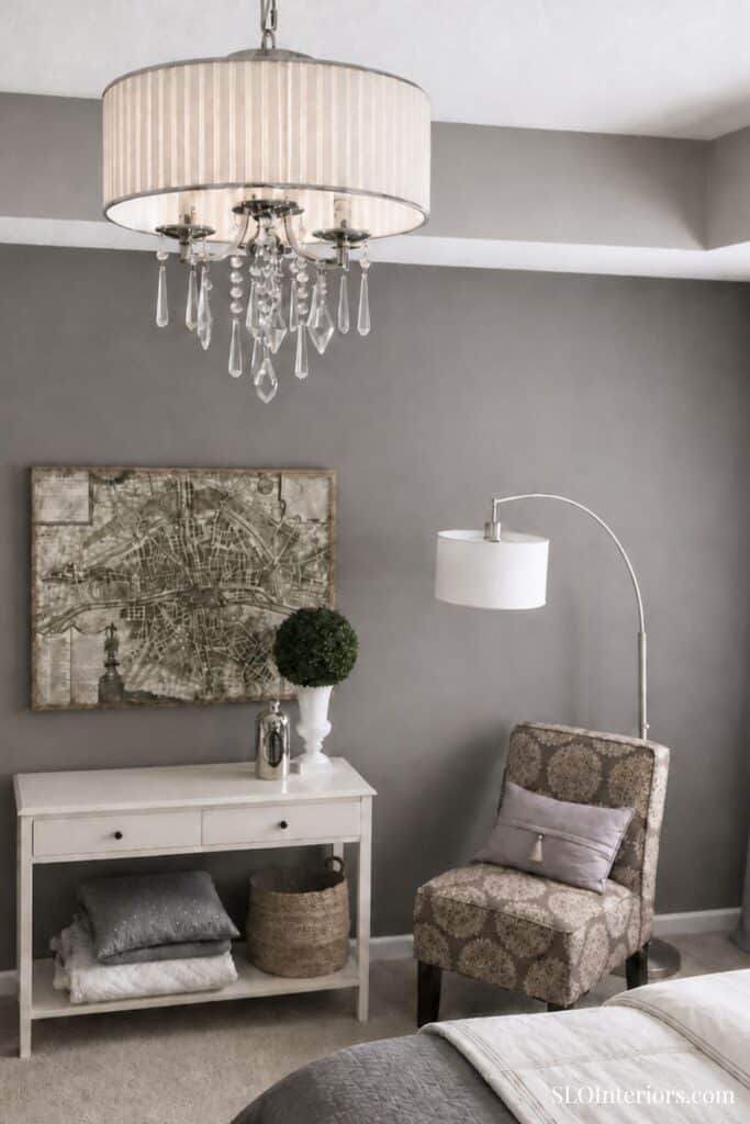 Elegant gray living room with chandelier, armchair, and decorative accents for stylish interior desi.