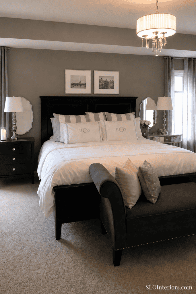 Elegant bedroom with black furniture, neutral decor, and soft lighting.