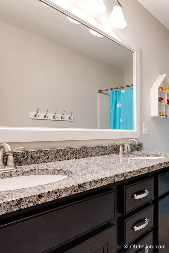 Modern bathroom vanity with granite countertop and dual sinks.
