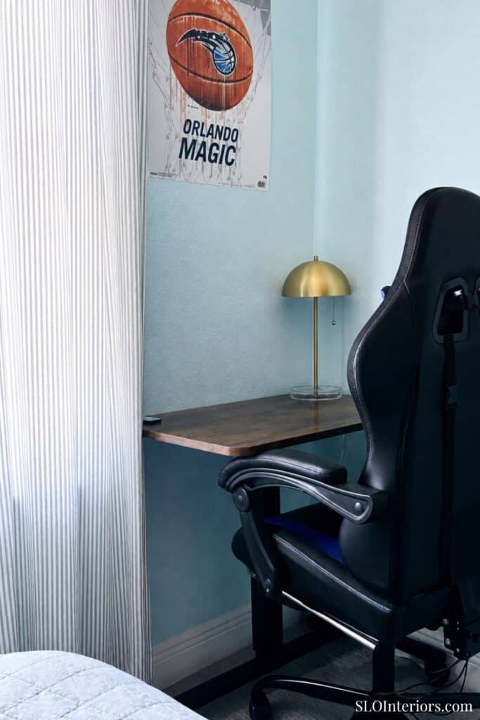 Home office with a desk, gold lamp, and Orlando Magic poster.