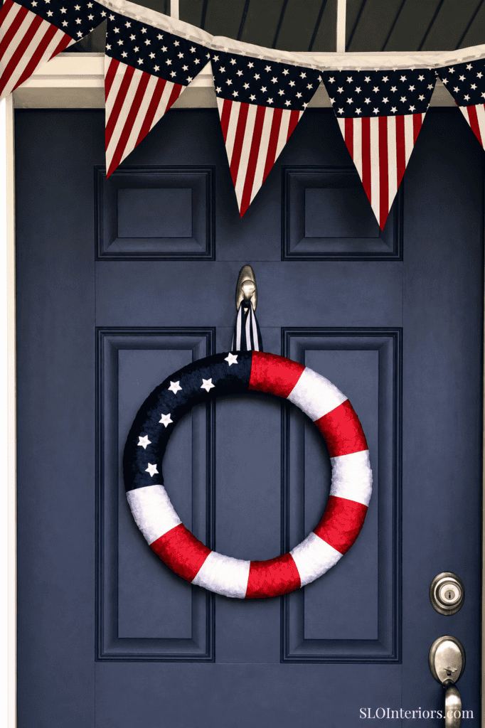 Patriotic door decoration with American flag bunting and wreath for Independence Day.