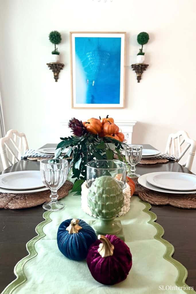 Elegant dining table with fall-themed centerpiece and modern decor.